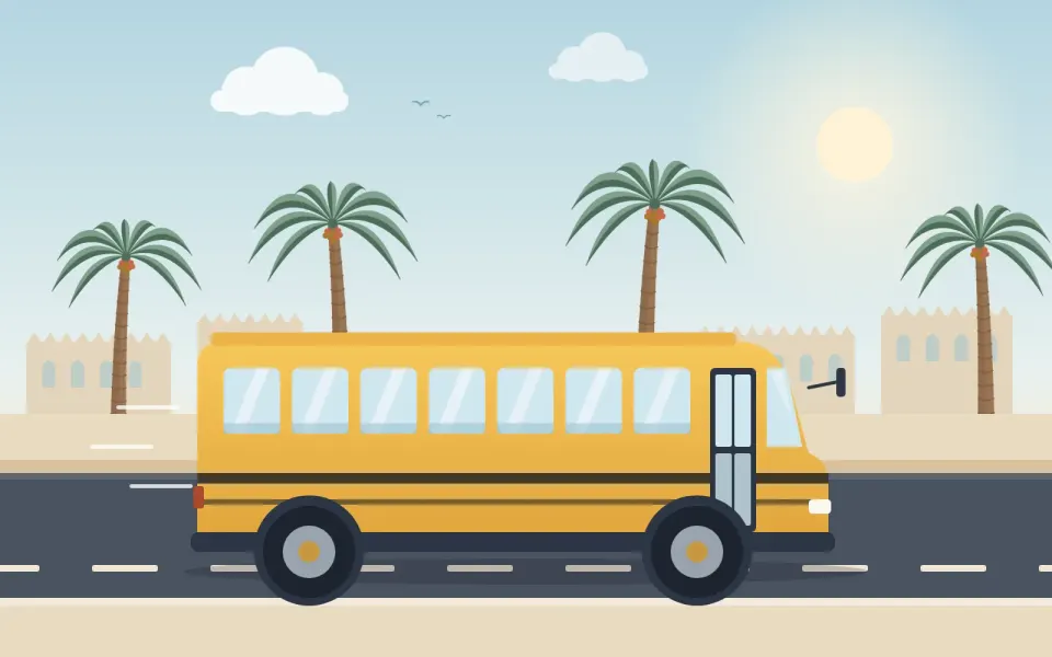 حافلة مدرسية صفراء على الطريق بين النخيل